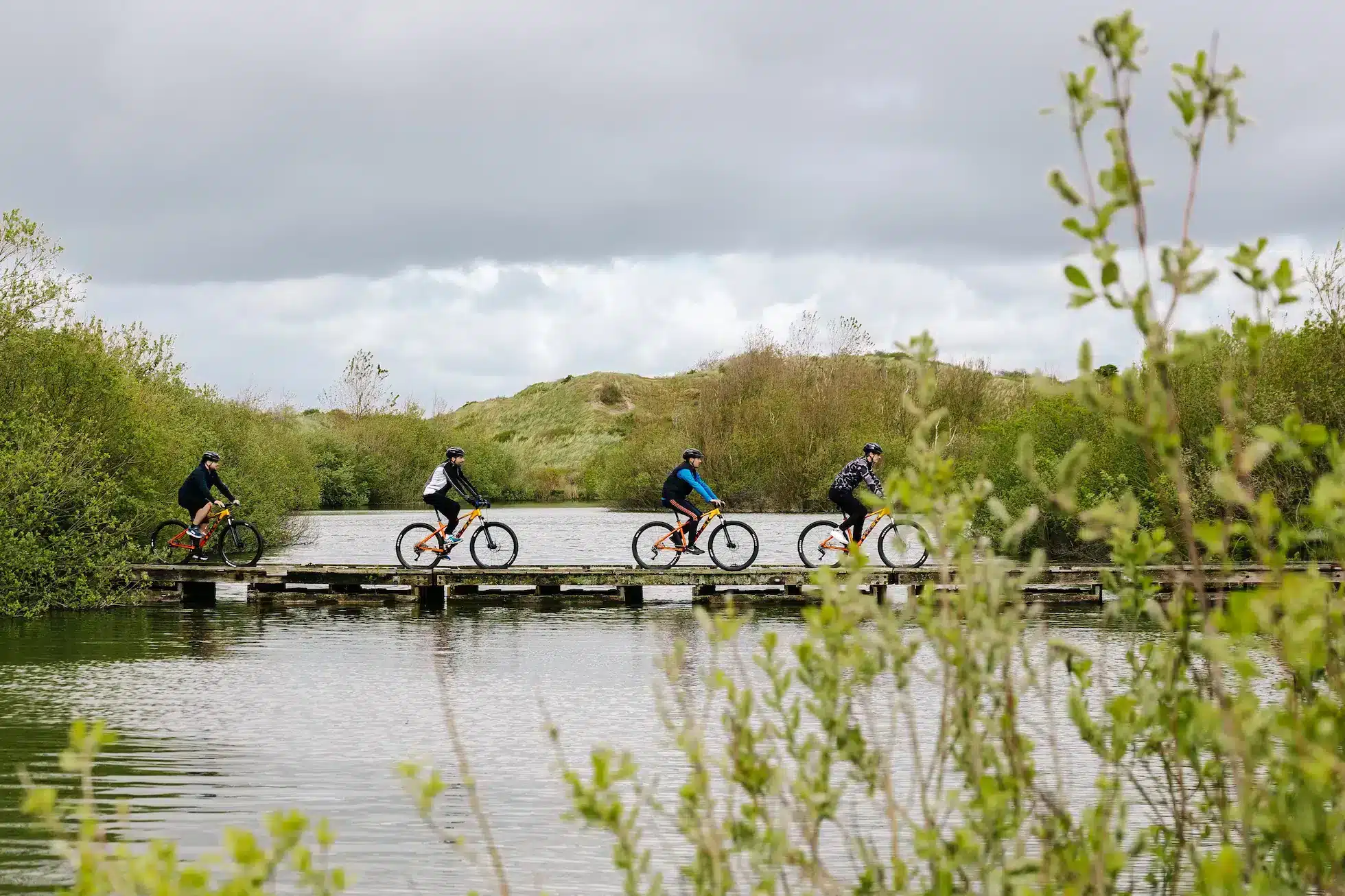 Mountainbikers rijden over brug over water op MTB Parcours Zandvoort