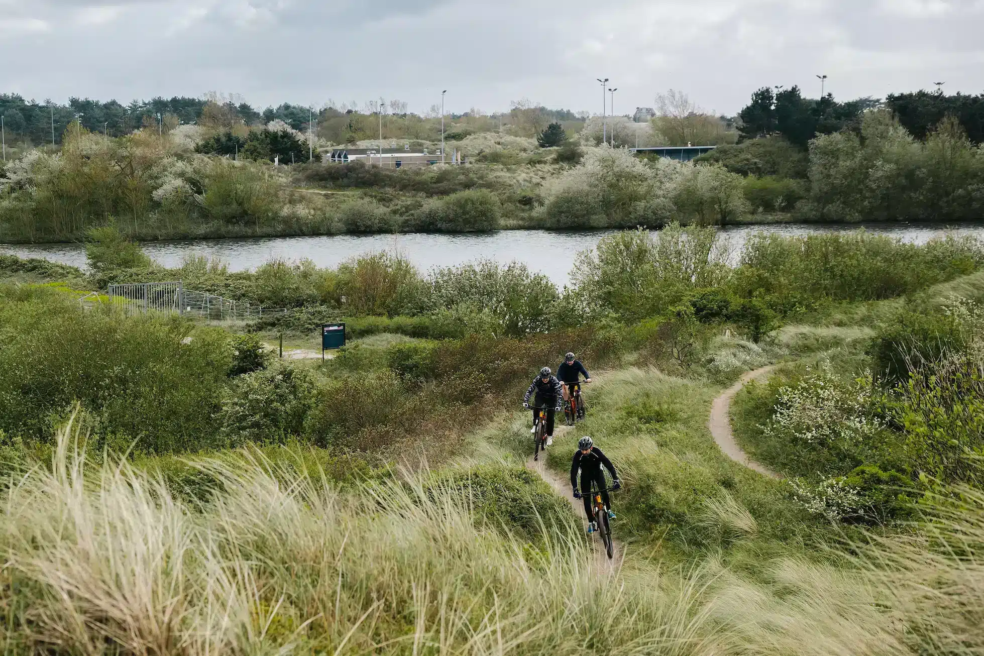 Mountainbikers fietsen door duinen Zandvoort