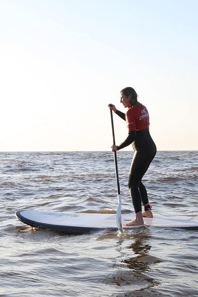 Vrouw is aan het suppen op zee in Zandvoort.