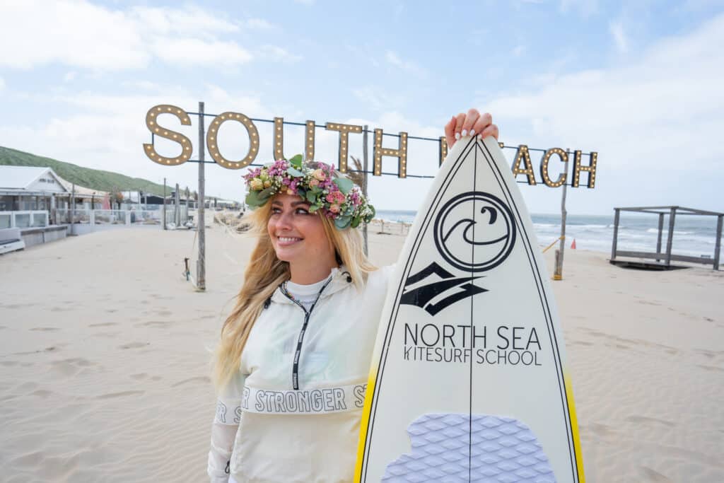 Vrouw met surfplank poseert bij het south beach bord