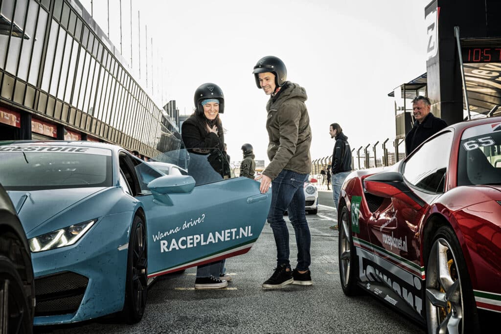 Twee mensen bij een auto van race planet in de pitbox van Circuit Zandvoort tijdens een race experience