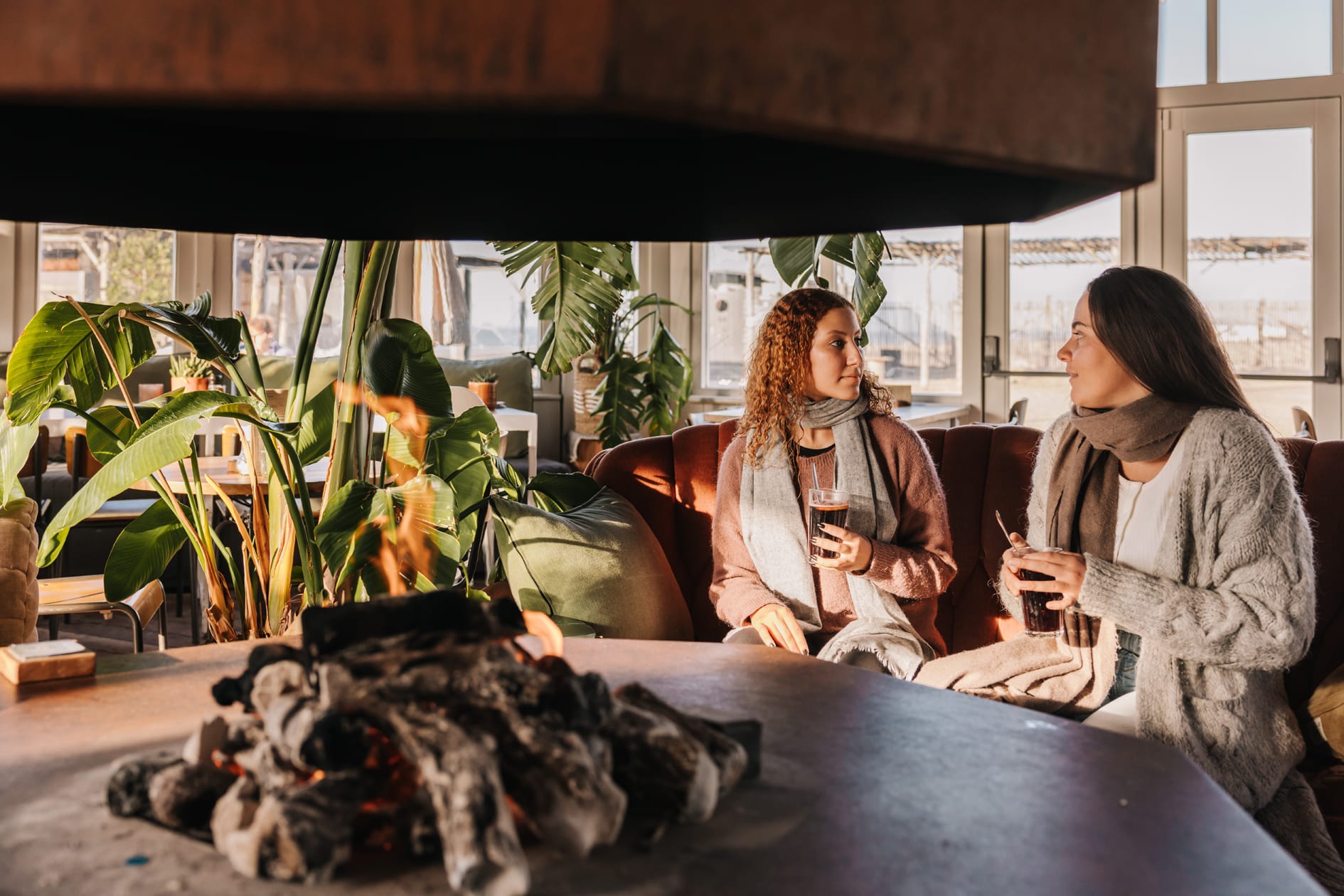 2 vrouwen bij de open haard binnen bij Nius Beach House