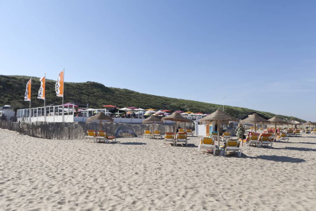 Strandbedjes en parasols bij strandpaviljoen Ohana