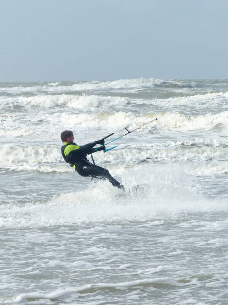 Kitesurfer vertrekt van het strand en begint te kitesurfen