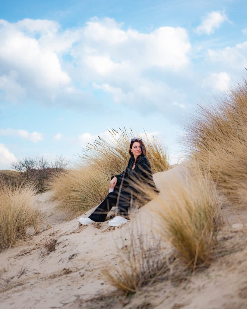 Vrouw zittend op een zandduin in Nationaal Park Zuid-Kennemerland, Bloemendaal, Zandvoort