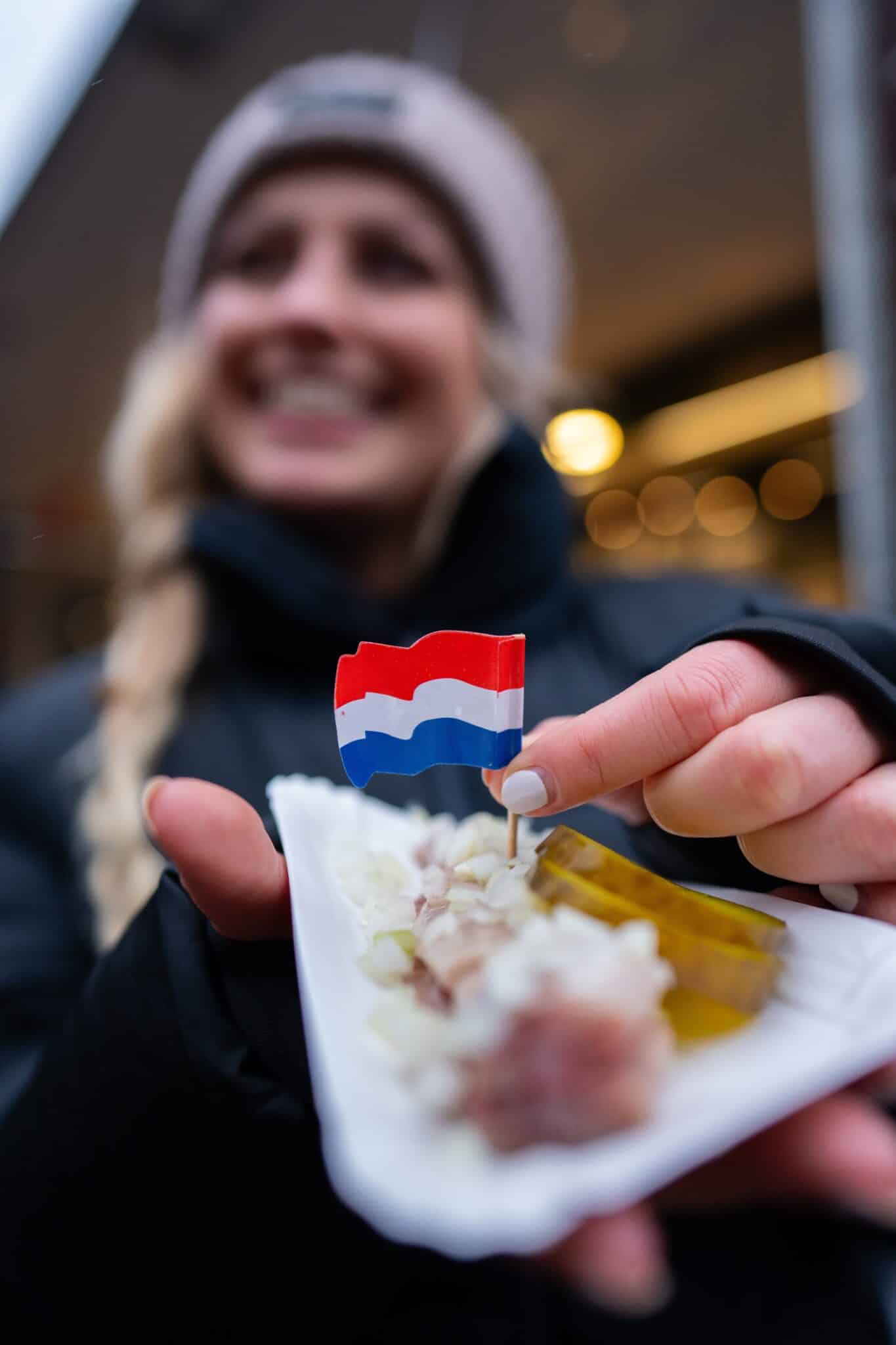 Lachende vrouw met haring in haar hand.