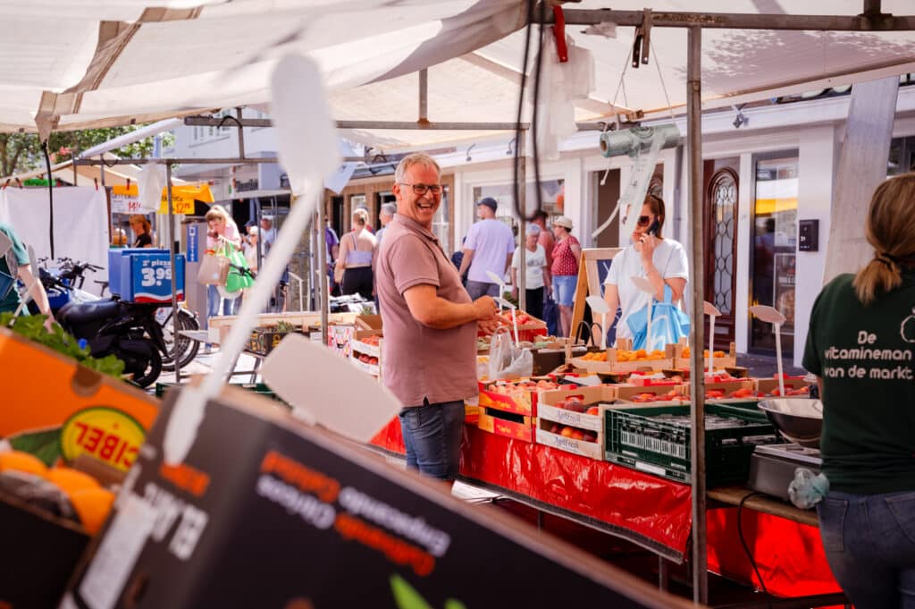 Een lachende verkoper staat op de markt in het centrum van Zandvoort.