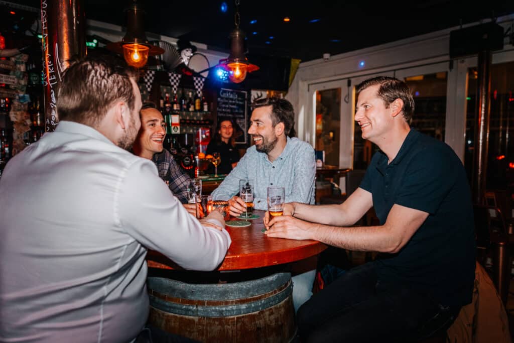 4 vrienden in cafe friends in Zandvoort drinken een biertje