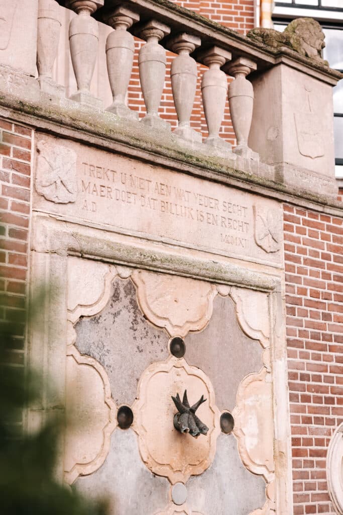 close up van de plaquette op het monumentale raadhuis