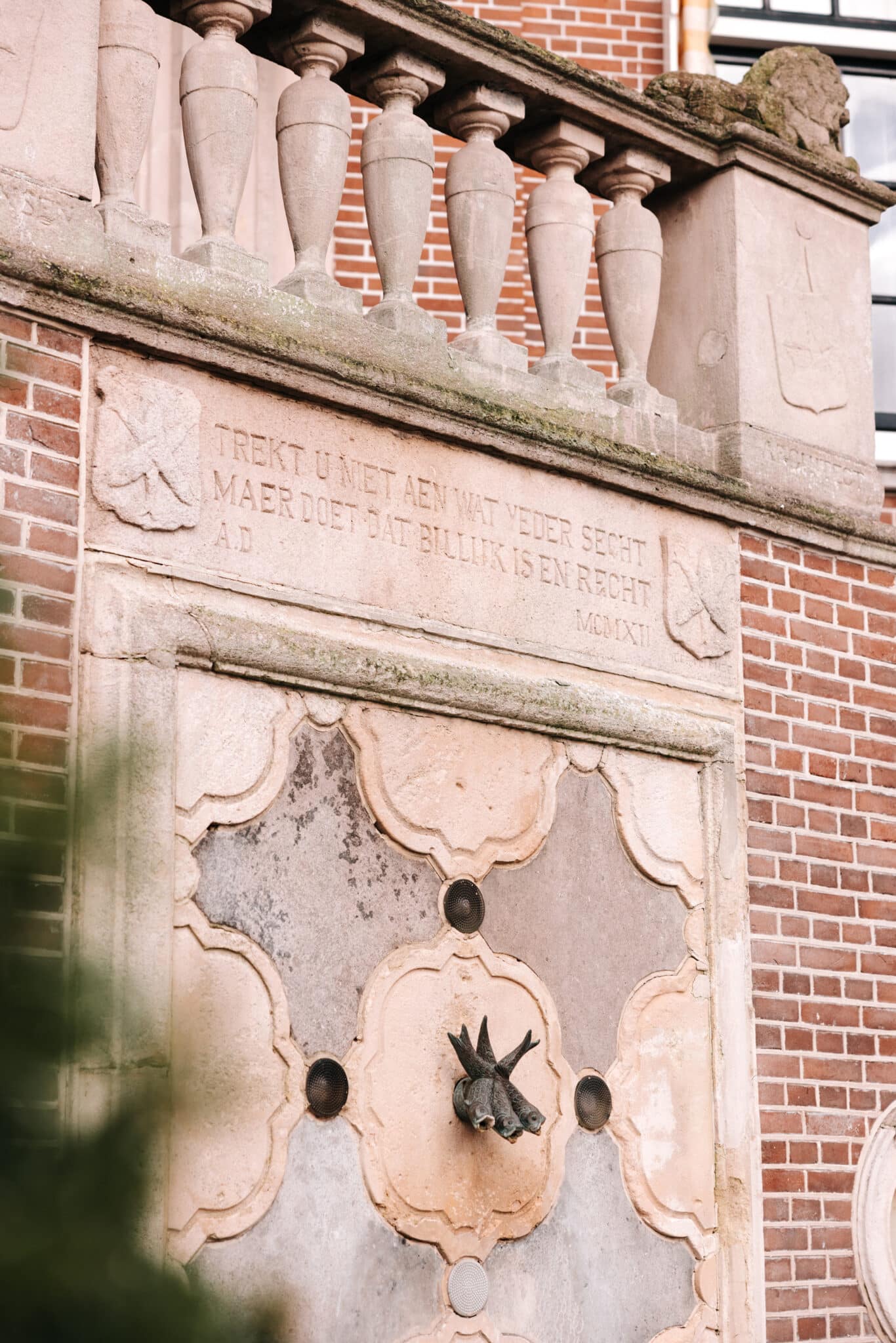 close up van de plaquette op het monumentale raadhuis