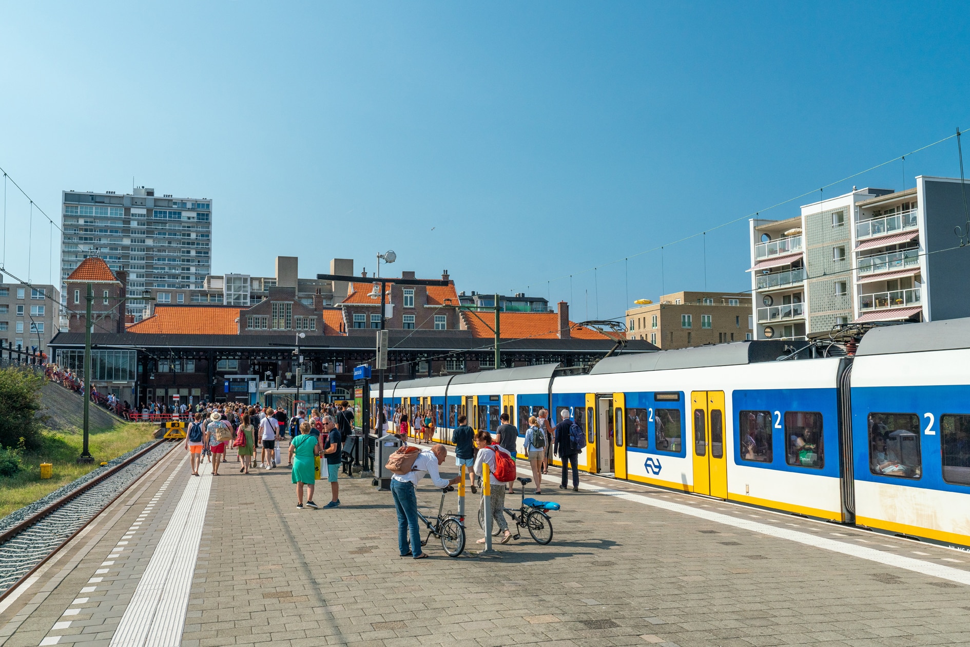 Mensen stappen uit de trein vanuit Amsterdam via Haarlem op station Zandvoort aan Zee