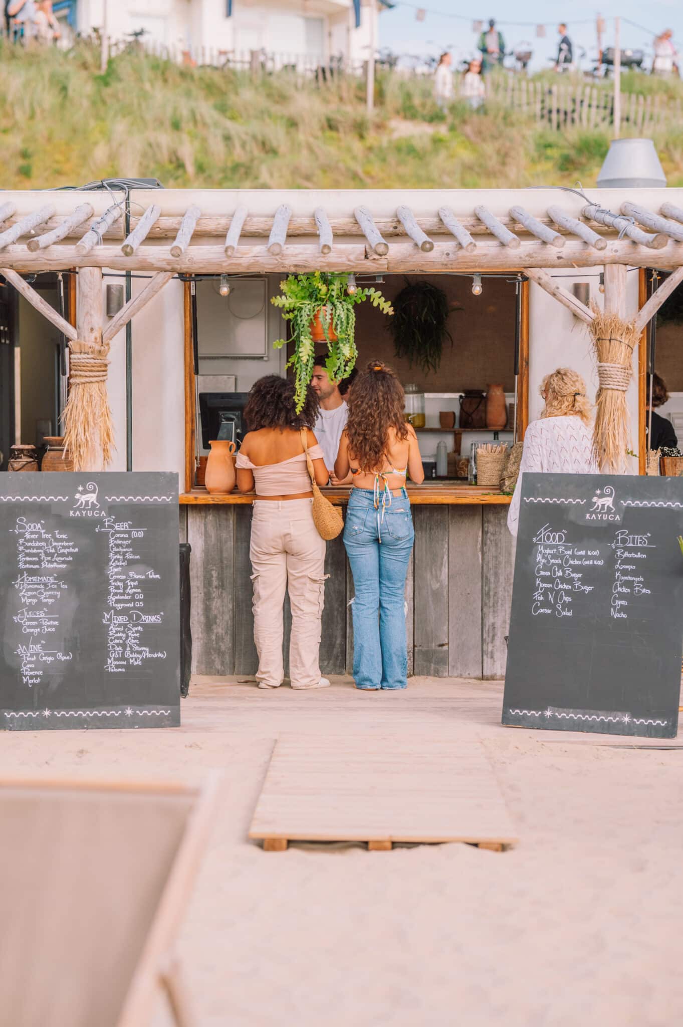 Twee vriendinnen bestellen iets bij de beachbar op het strand.