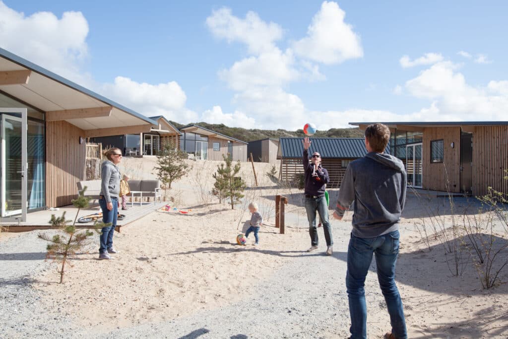 mensen spelen een balspel in het zand bij vakantiepark roompot Bloemendaal