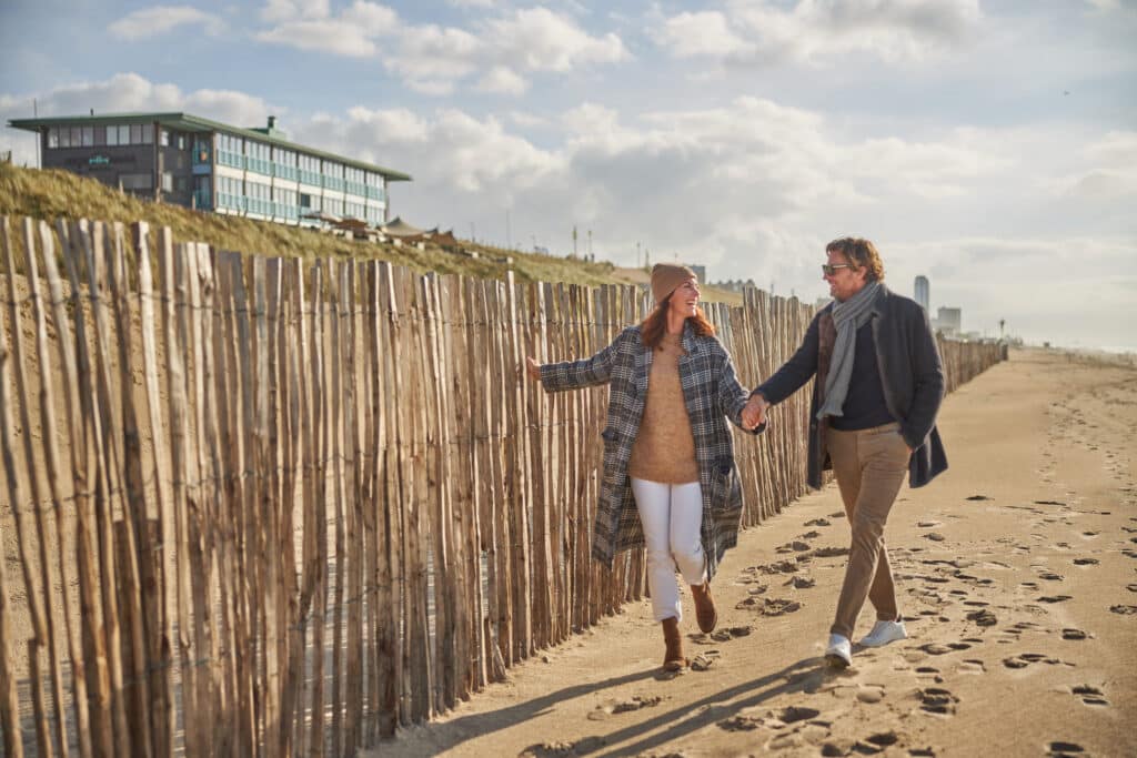 Twee gasten van Beachhouse hotel lopen vanuit het hotel het strand op.