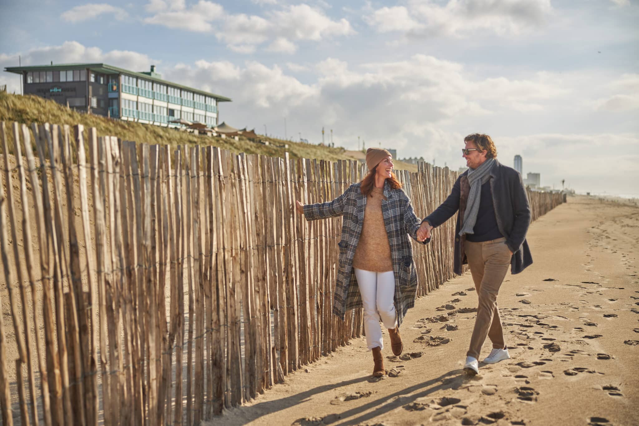Twee gasten van Beachhouse hotel lopen vanuit het hotel het strand op.
