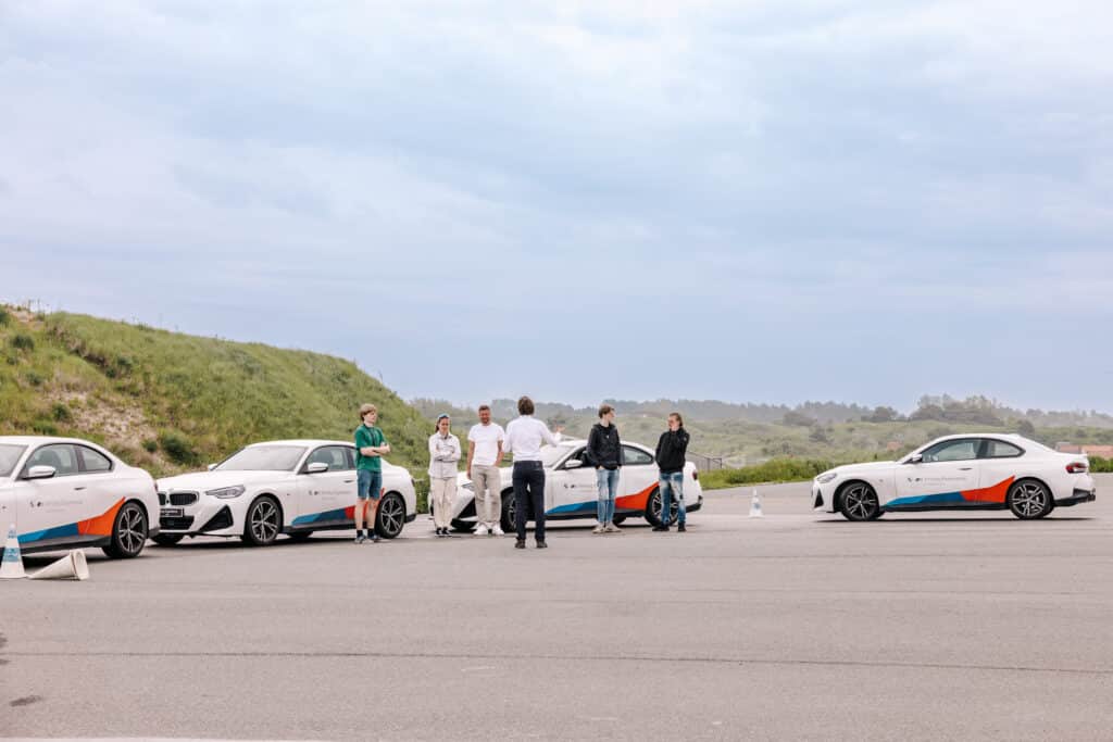 Groep luistert naar een instructeur van BMW driving experience slotemakers voorafgaand aan een slipcursus
