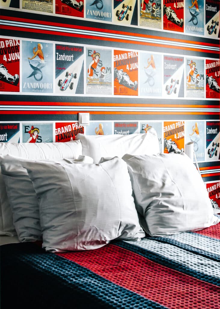 Overnachten in een racehuisje bij Roompot Zandvoort, met een kamer ingericht met raceposters achter het bed.