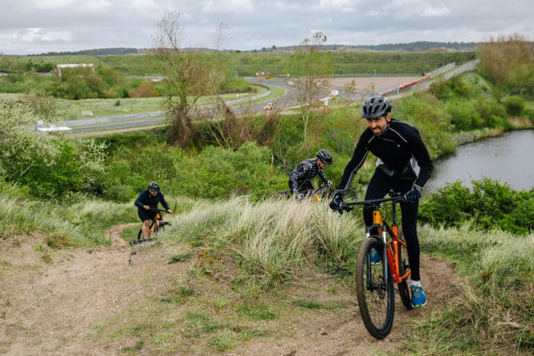 Mountainbikers fietsen over het MTB parcours langs Circuit Zandvoort