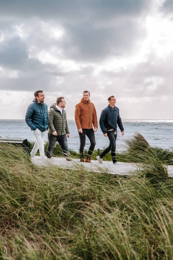 Vier mannen wandelen over de boulevard