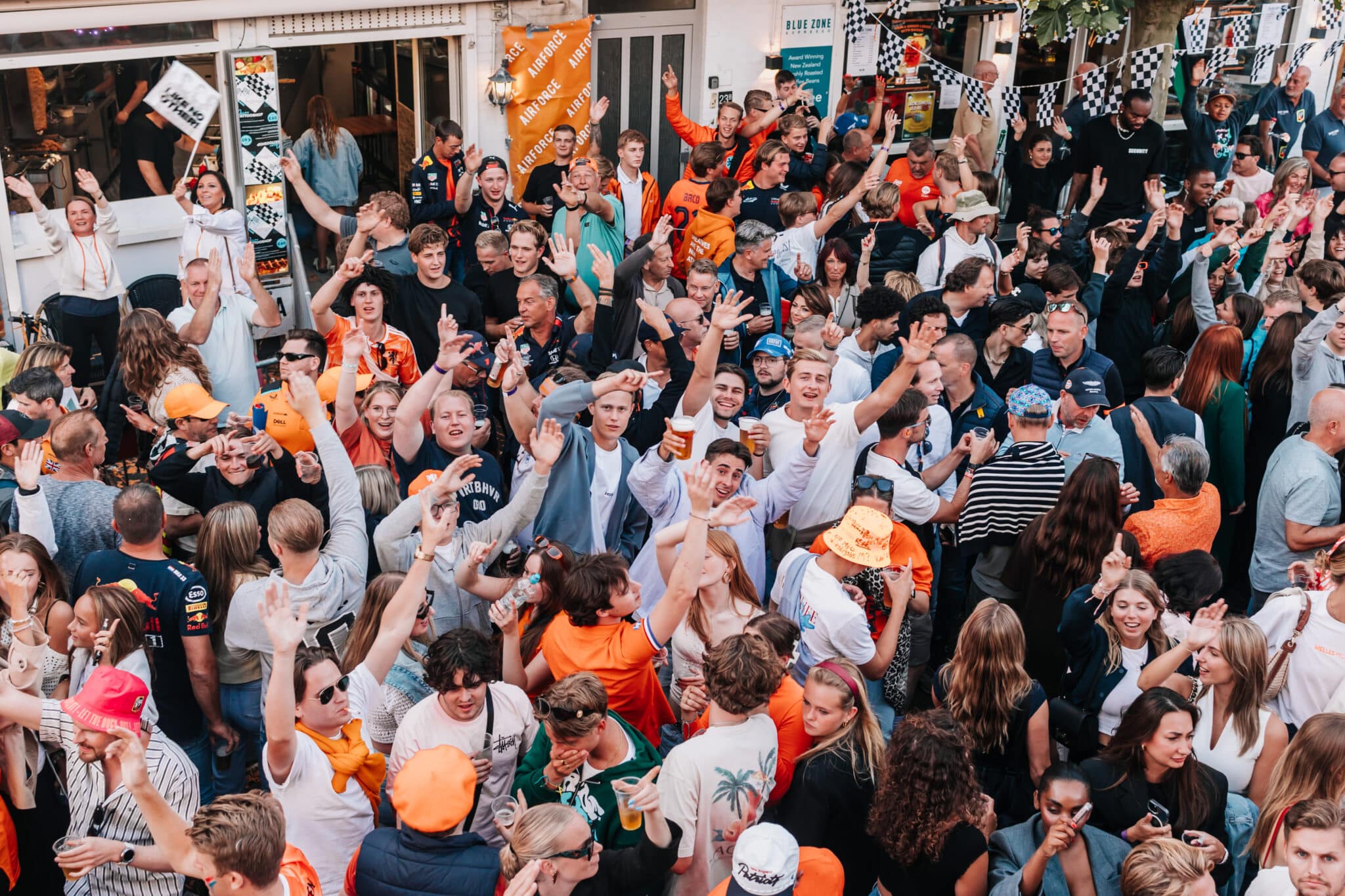 Feestende mensen in de haltestraat tijdens het Zandvoort Racefestival.