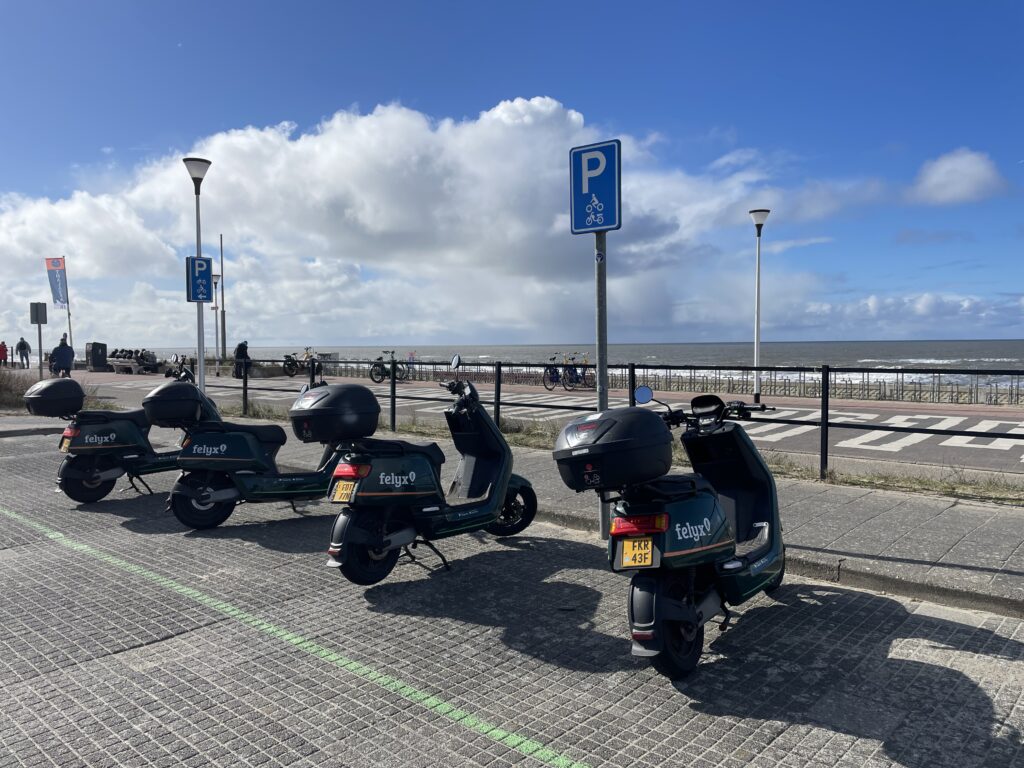 Vier deelscooters van Felyx op een rij geparkeerd op de boulevard