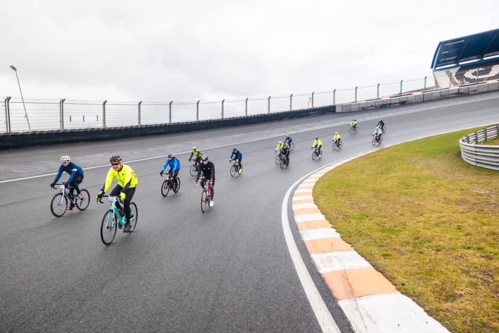 Deelnemers aan de omloop van zandvoort fietsen over Circuit Zandvoort