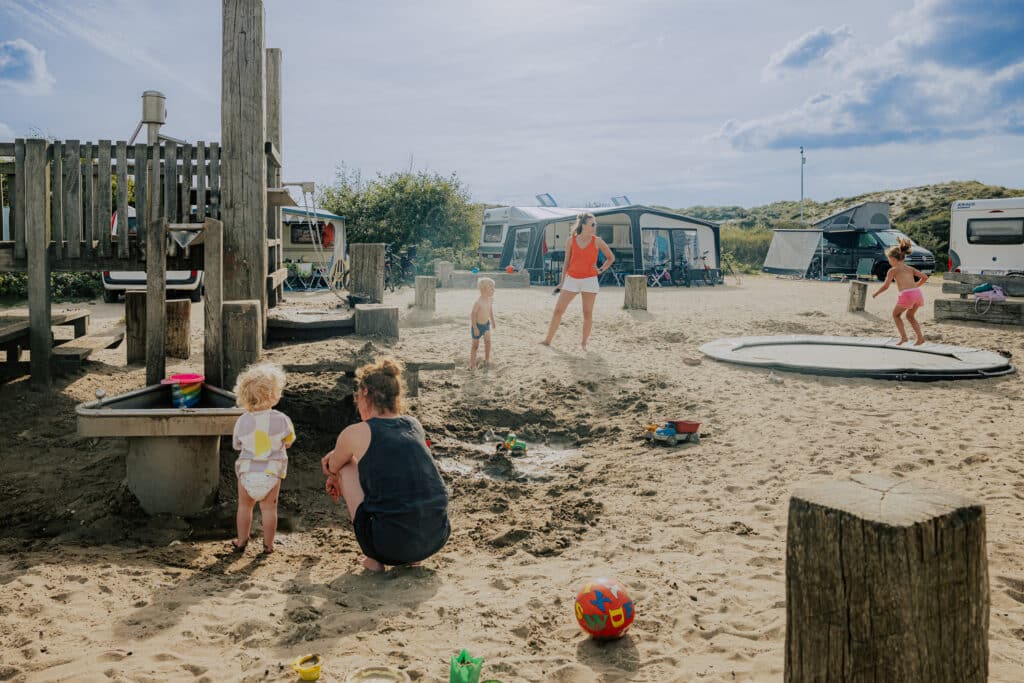 Spelende kinderen in de zand speeltuin van kindvriendelijke camping de lakens