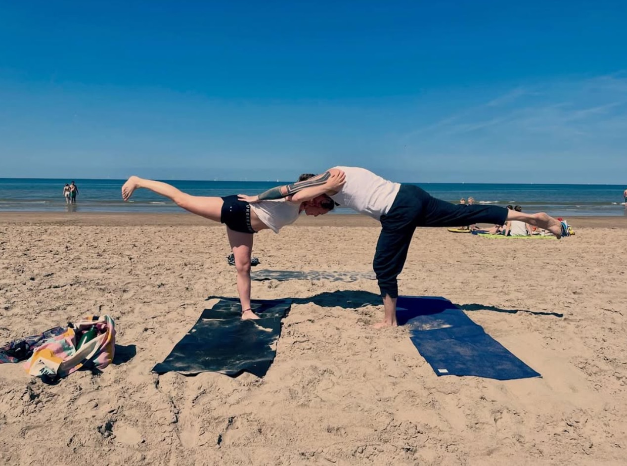 Twee mensen doen aan yoga op het strand - Yoga Shanti