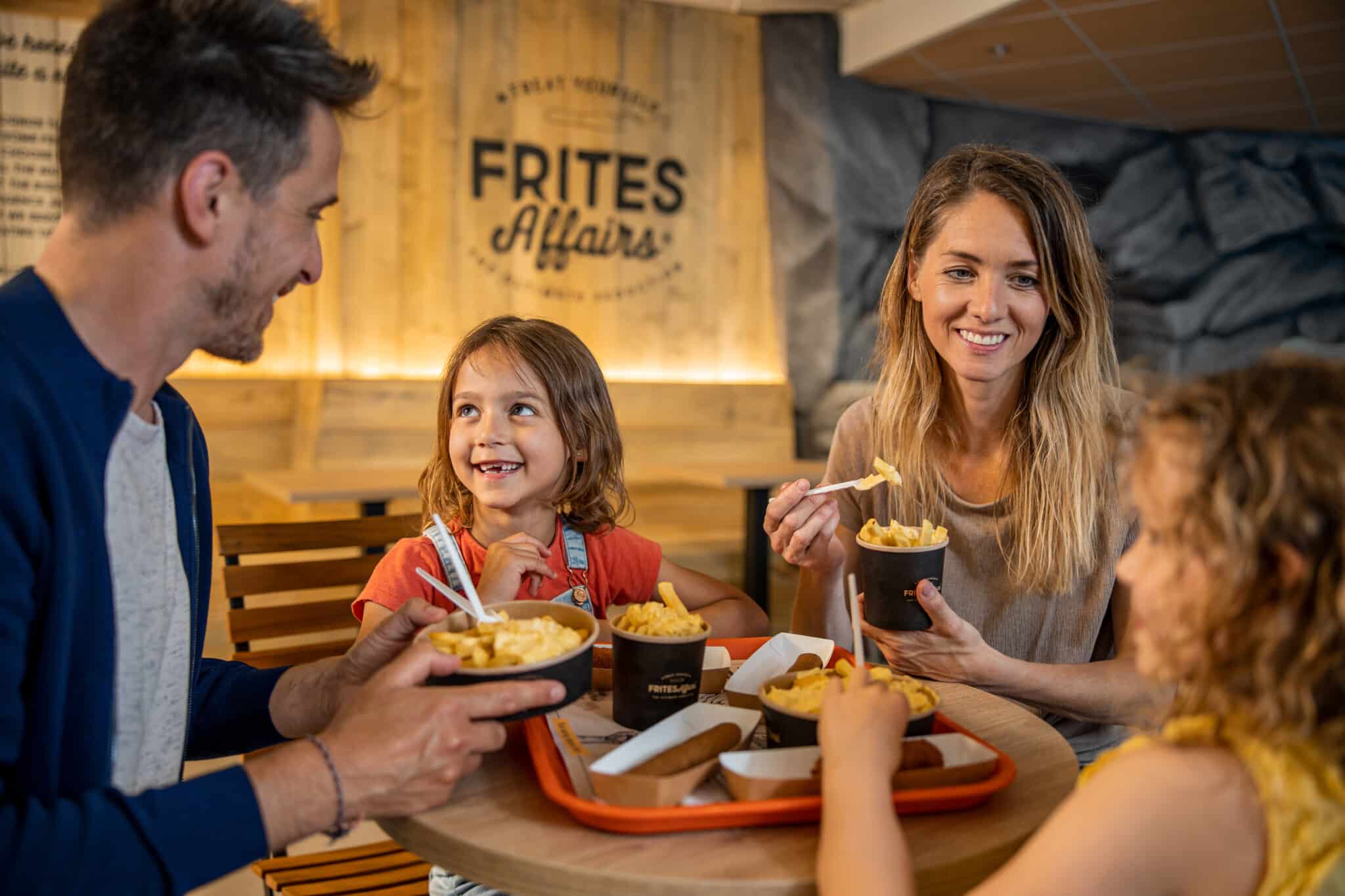 Gezin met kinderen zit bij Frites affairs in center parcs