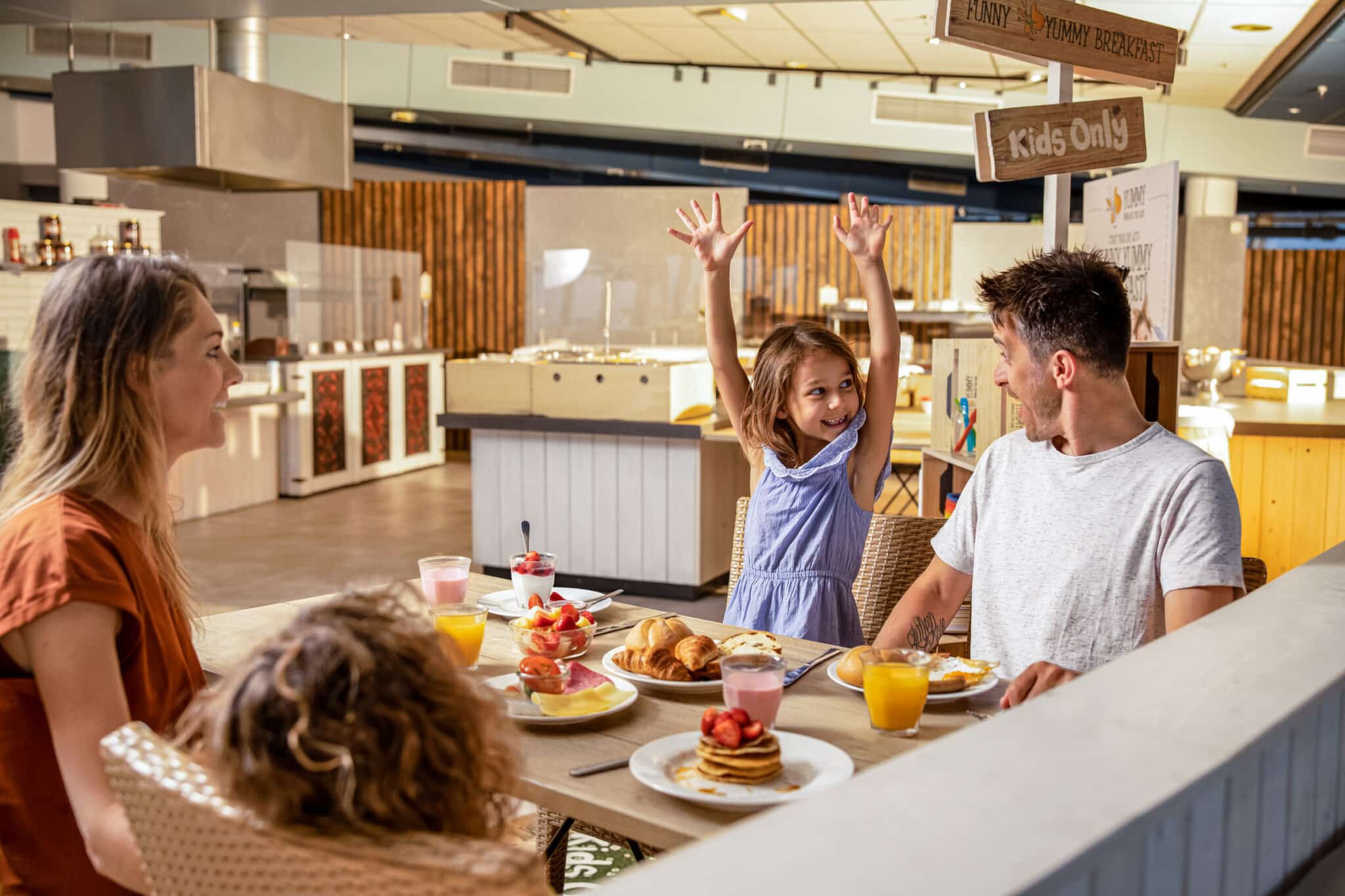 Een blij kindje tijdens ontbijt in een hotel in Zandvoort