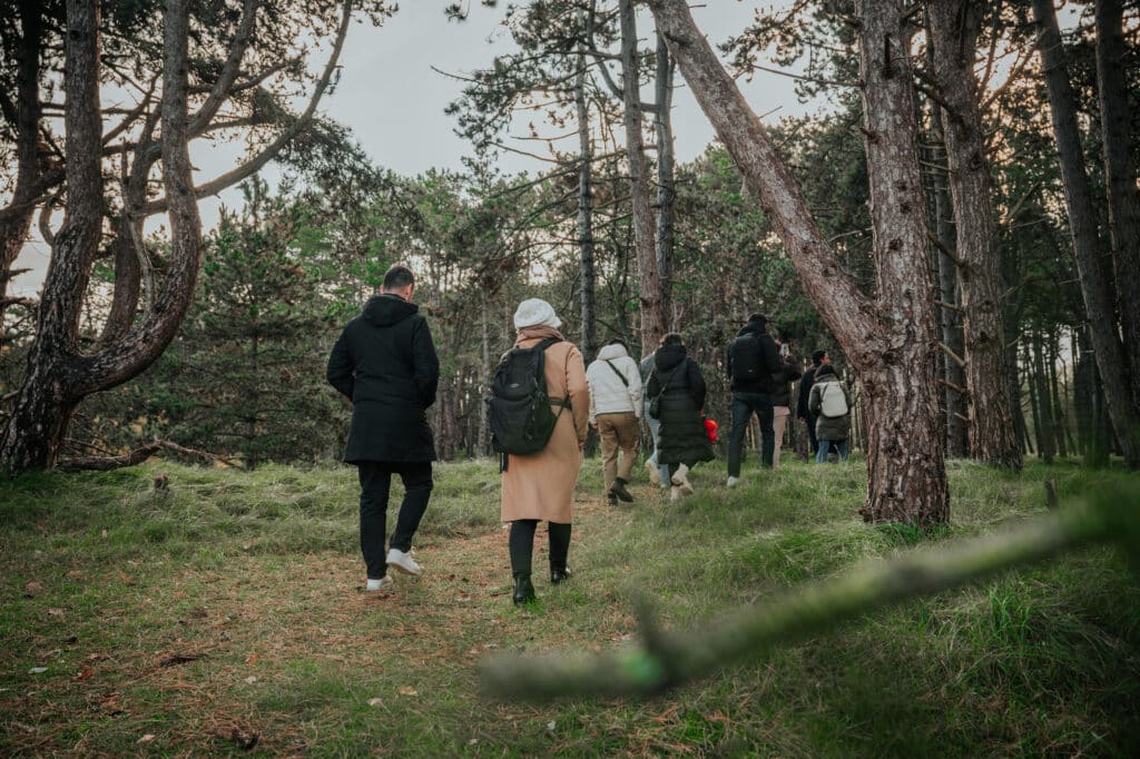 Groep mensen op een (zakelijk) bedrijfsuitje maken een wandeling met gids door de waterleidingduinen
