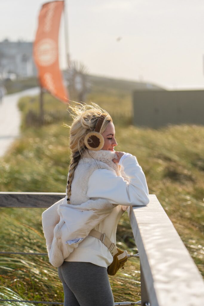 Vrouw geniet van de zon kijkend over zee.