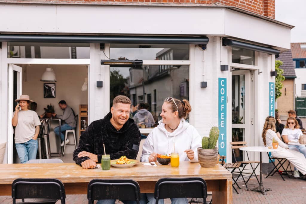 Man en vrouw ontbijten op het terras van Blue Zone
