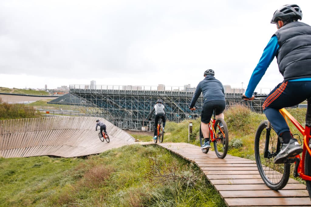 vier mannen rijden over het mountainbike parcours de laarwall op