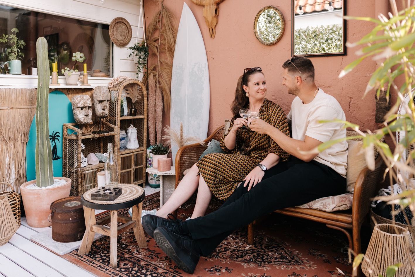 Man en vrouw proosten zittend op een bankje bij Tiny Paradise