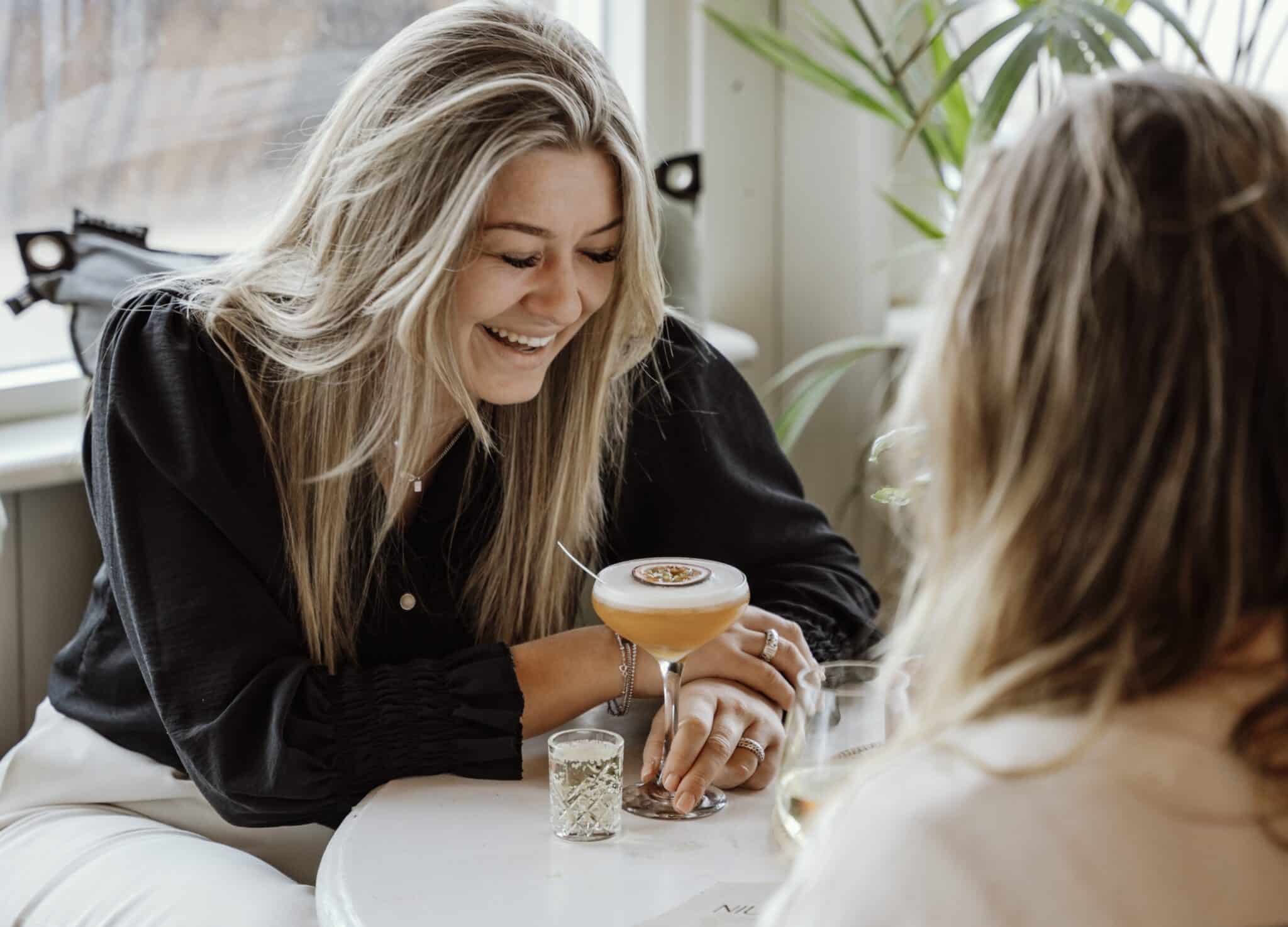 Vrouw lachend met een Pornstar Martini cockail