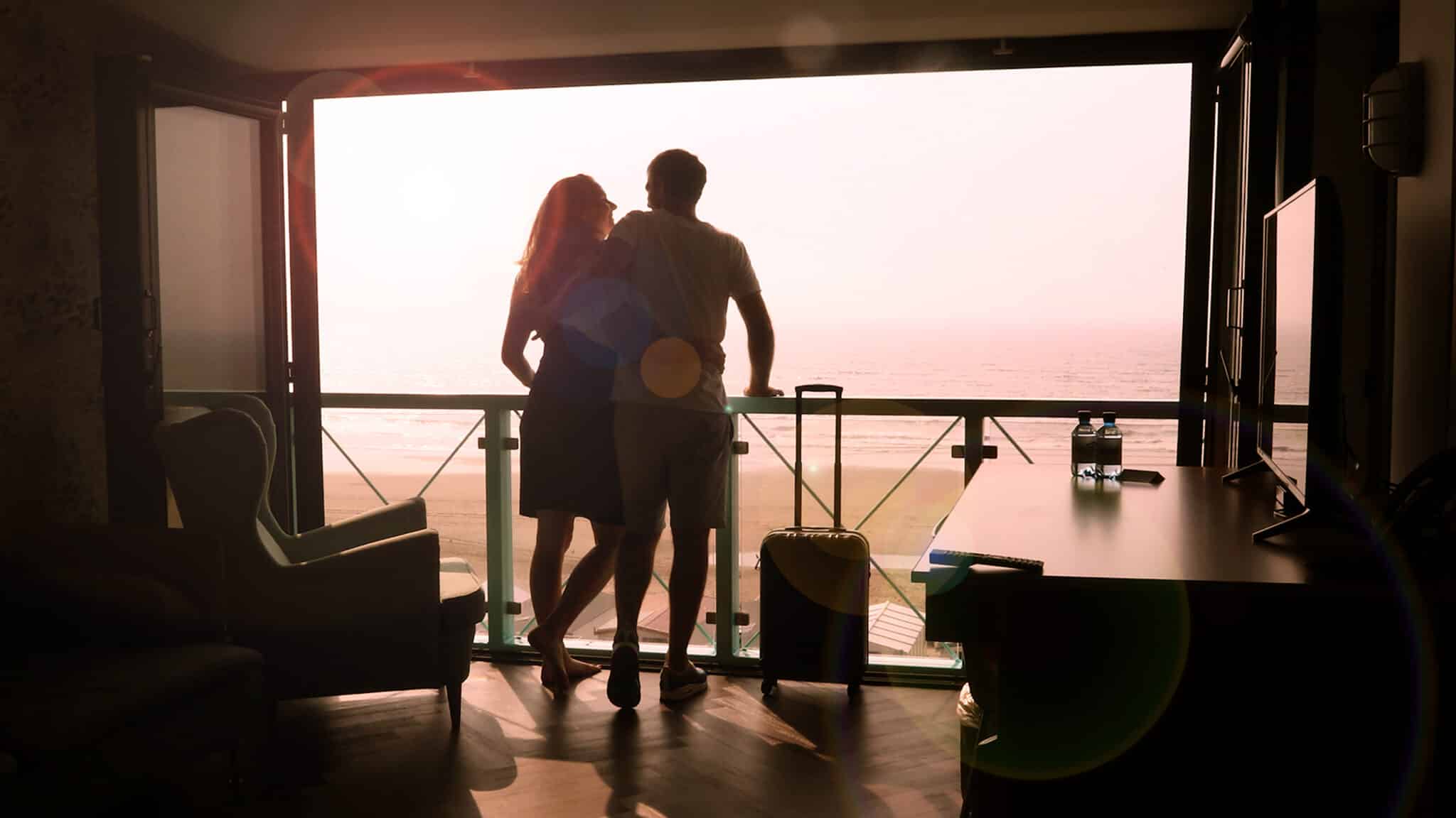 Beach House Hotel Zandvoort, twee personen die van het balkon naar de zee kijken.