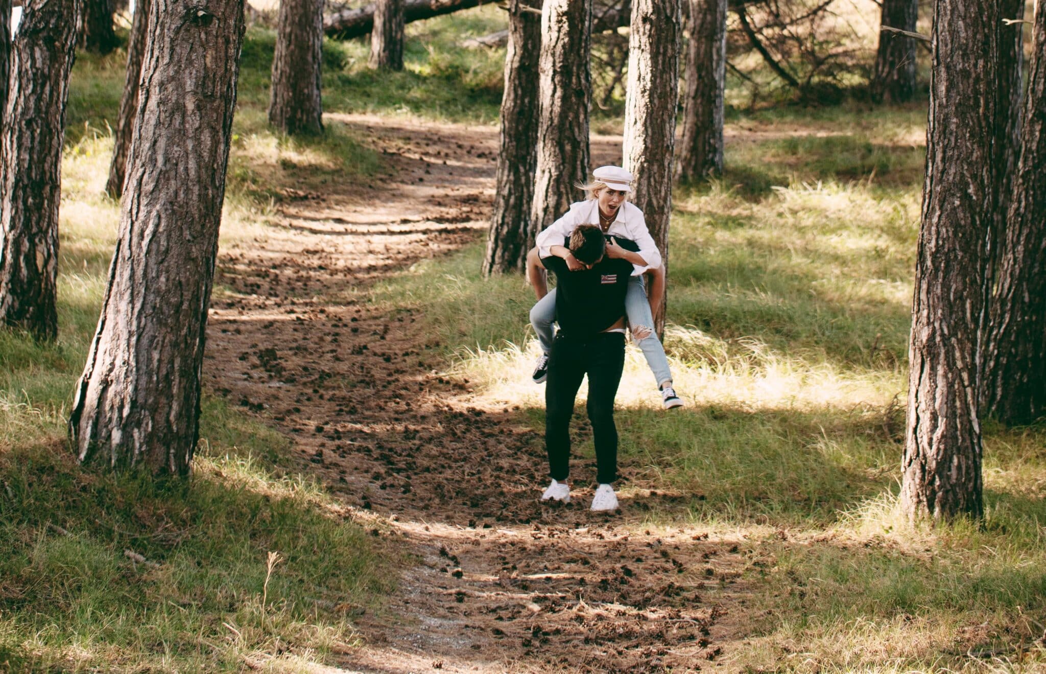 Vrouw op de rug van een man tijdens een wandeling door de Amsterdamse waterleidingduinen
