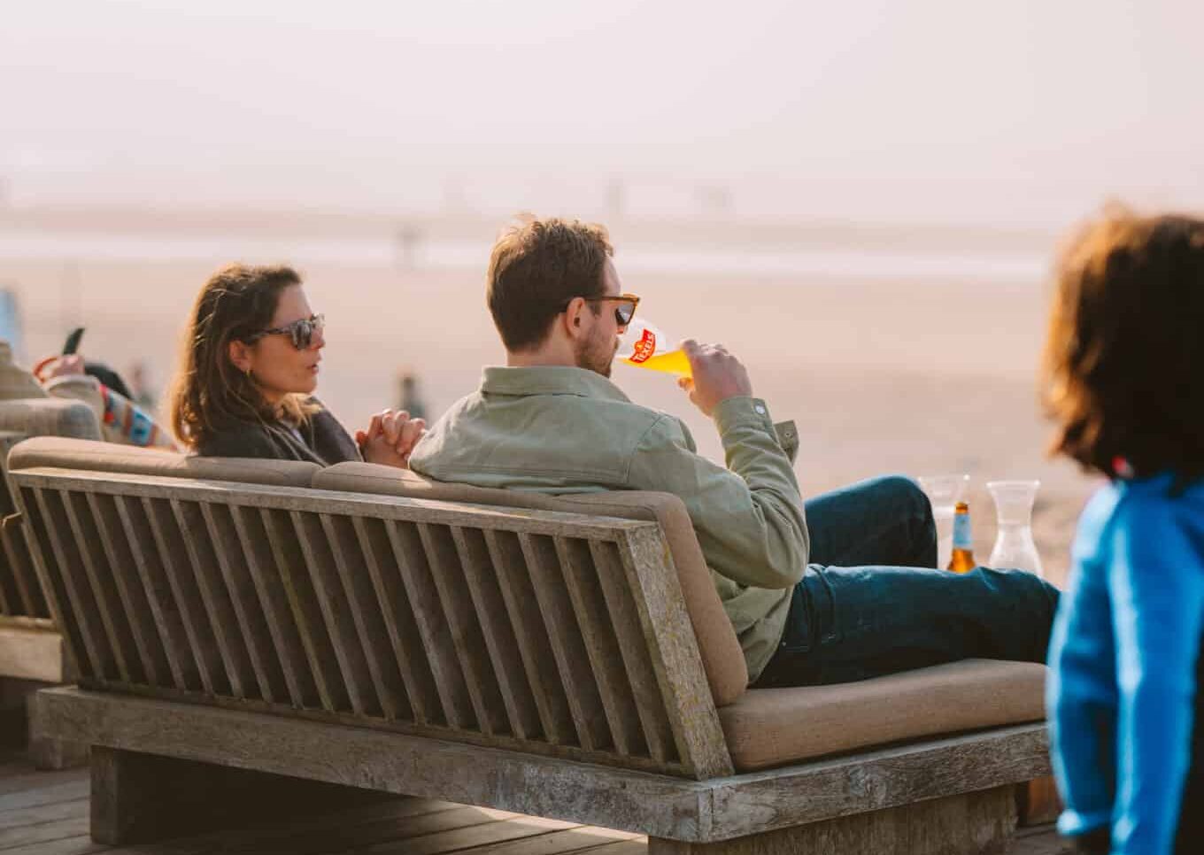 Man en vrouw op een terras van een strandpaviljoen in Zandvoort